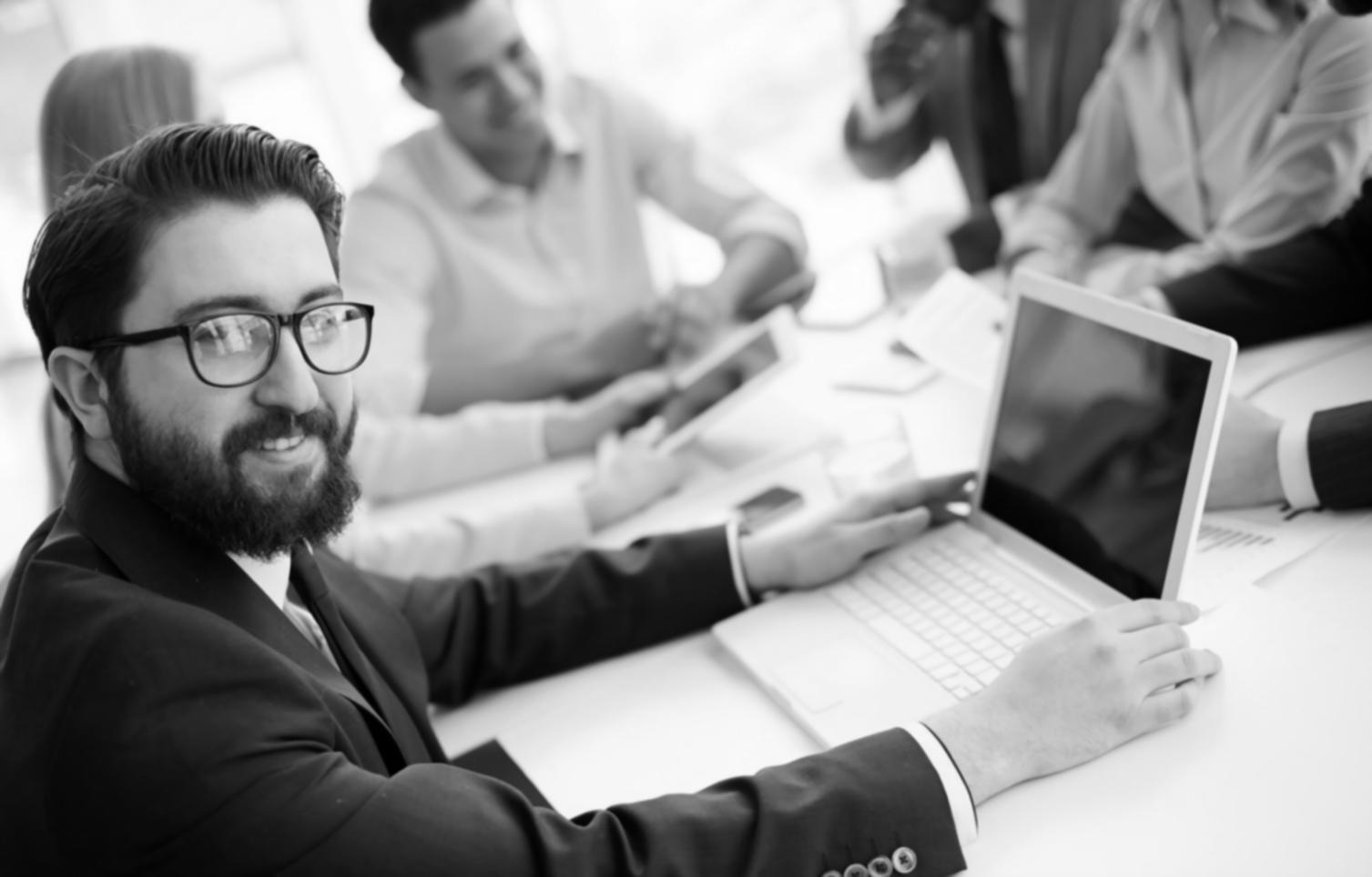 Laptop mit Tabellenkalkulationen und Geschäftsberichten auf Schreibtisch